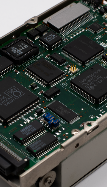 Close-up image of a vintage circuit board displaying microchips and electronic components.